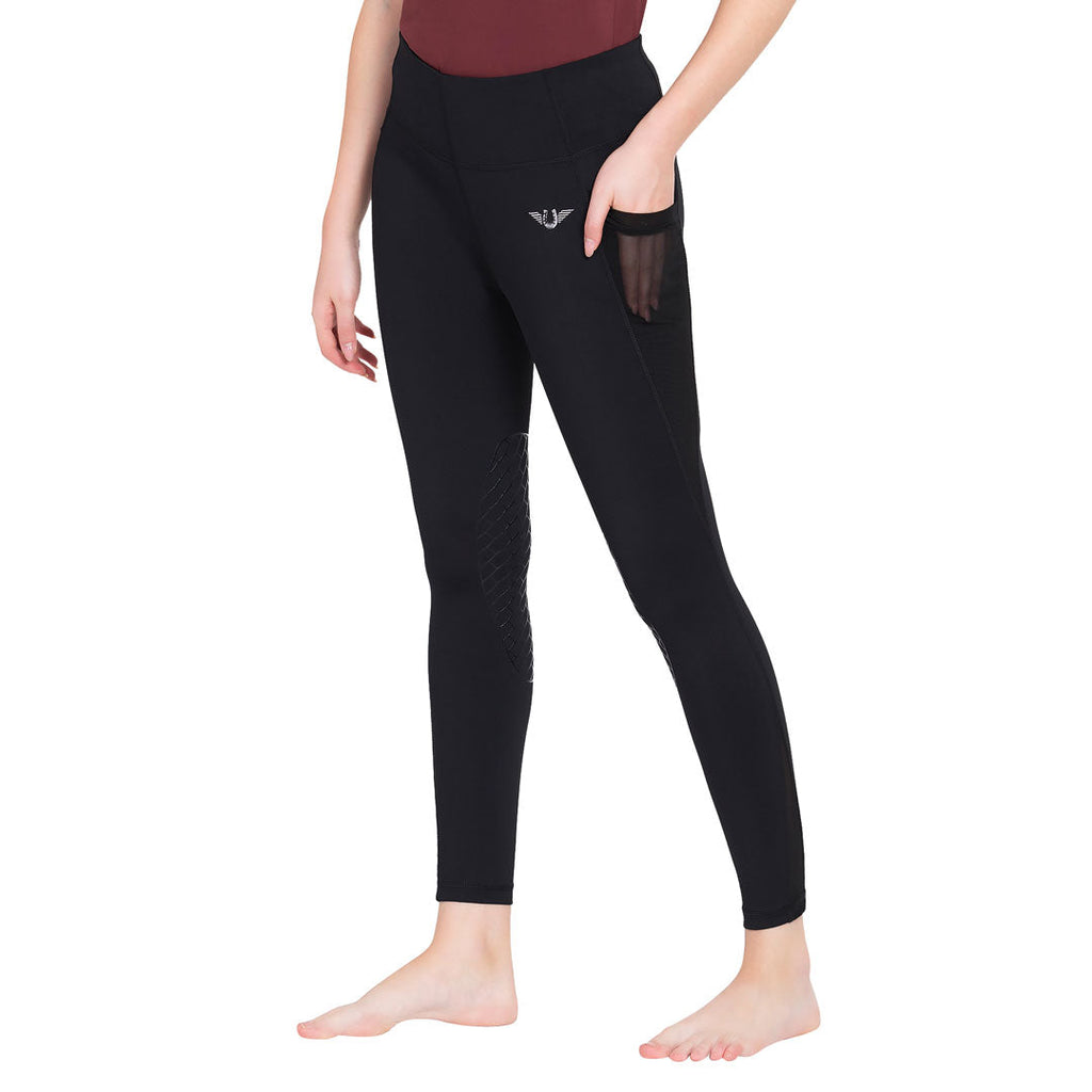 Person wearing black leggings with a small logo on a white background