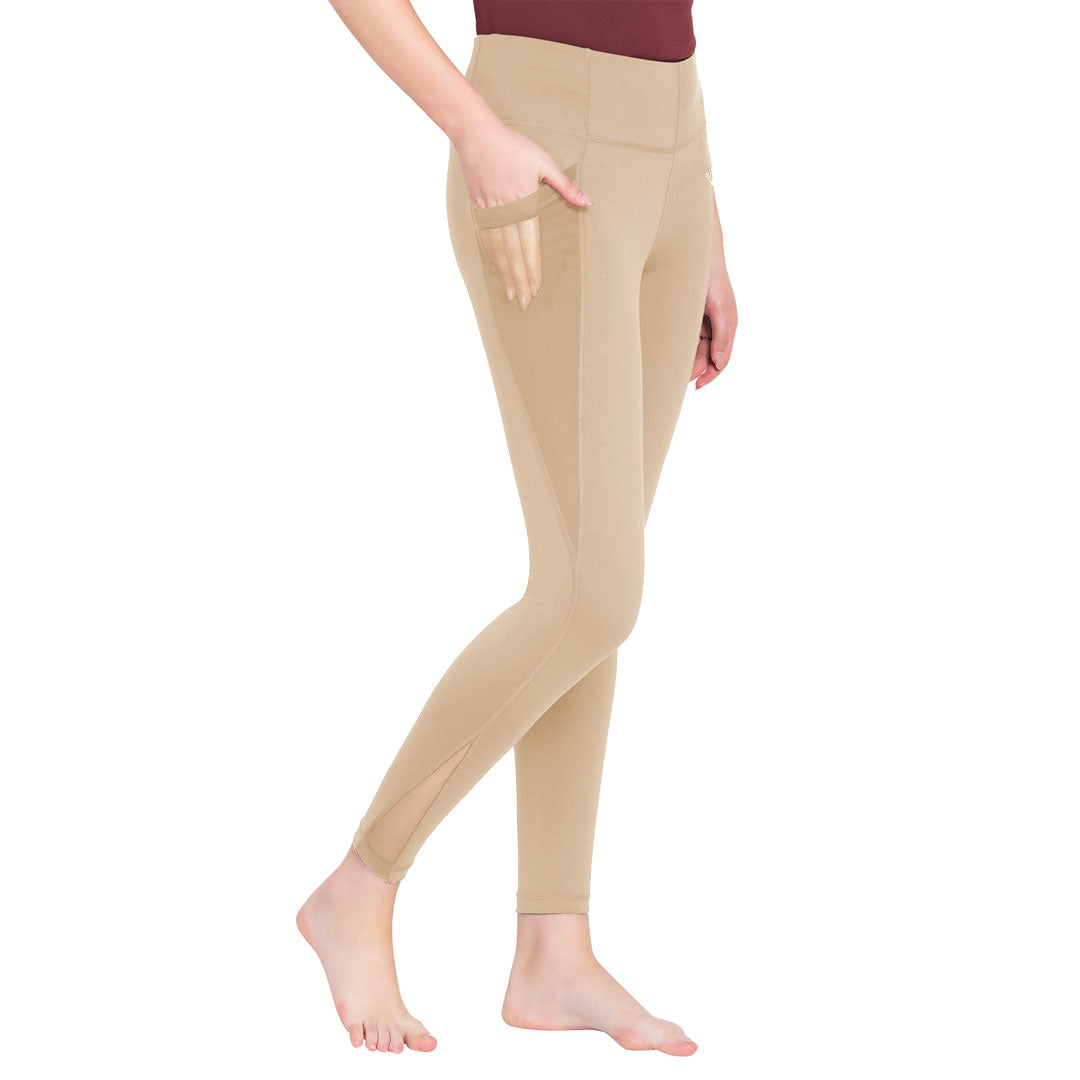 Beige leggings worn by a person on a white background