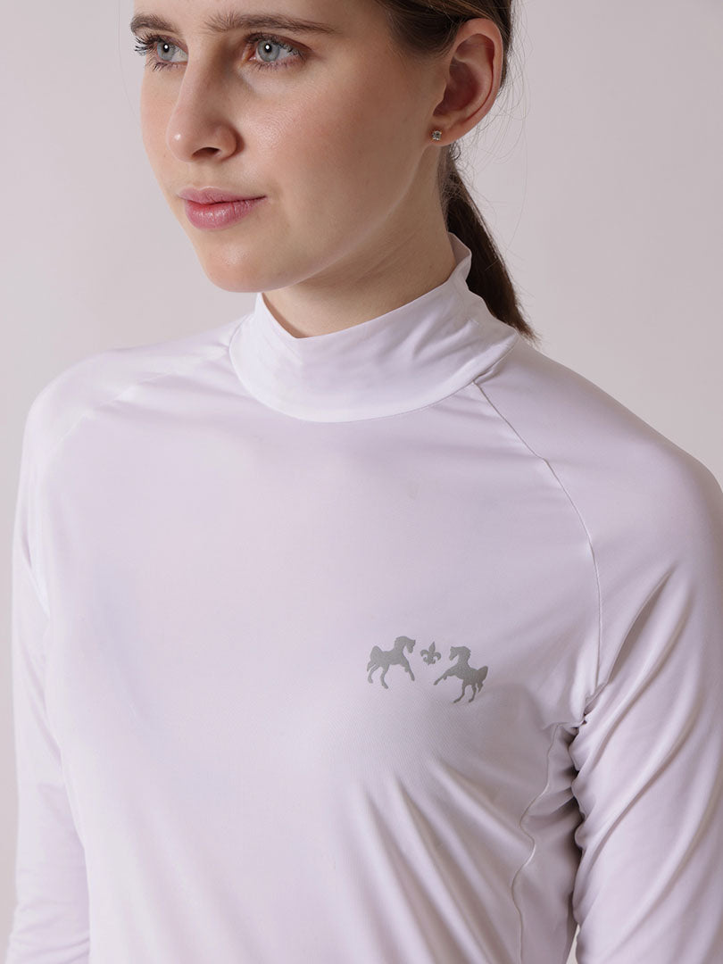 Woman wearing a white long-sleeve shirt with a logo on a plain background