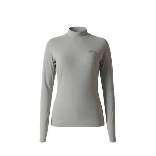 Woman wearing a light green long-sleeve top with a logo on a plain background