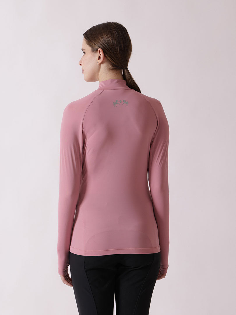 Woman wearing a pink long-sleeve athletic top on a light pink background
