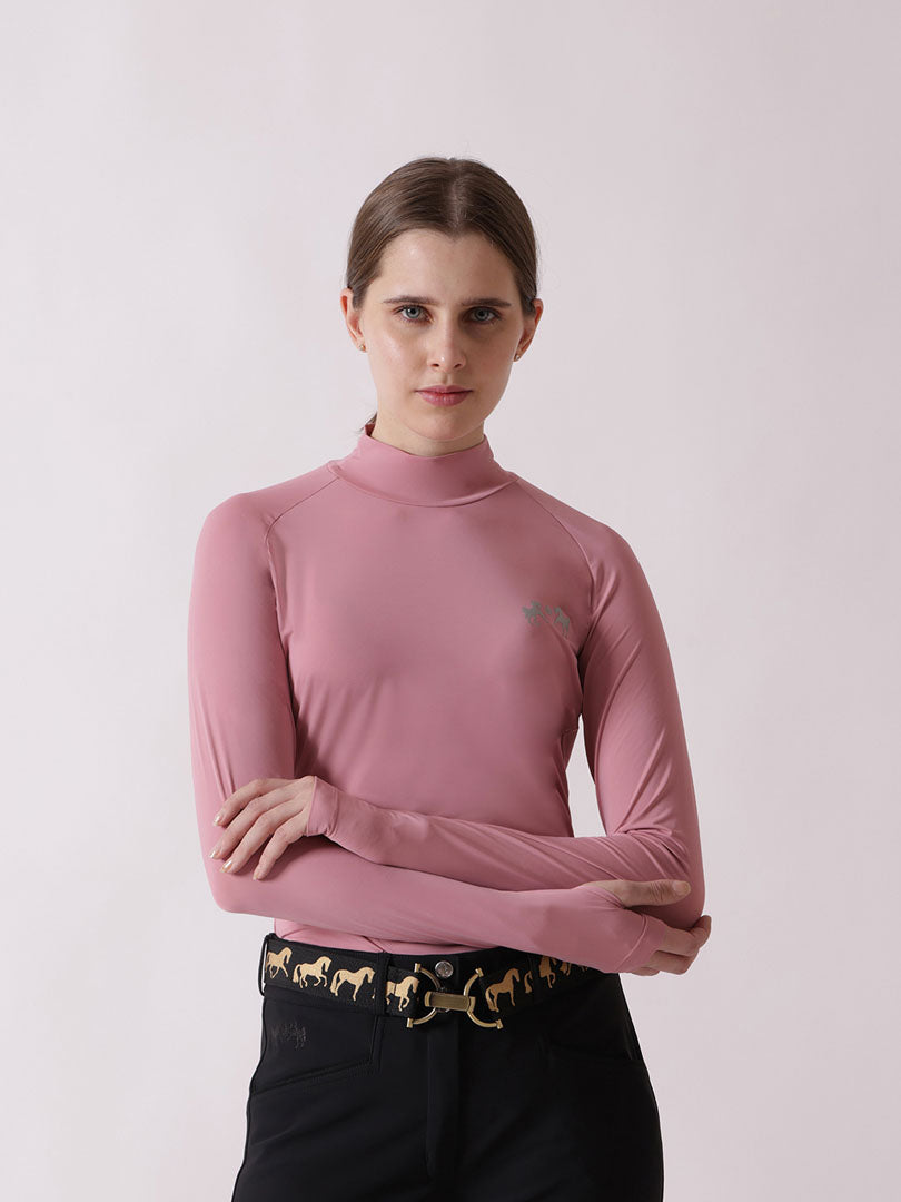Woman wearing a pink long-sleeve top with a logo on a light pink background