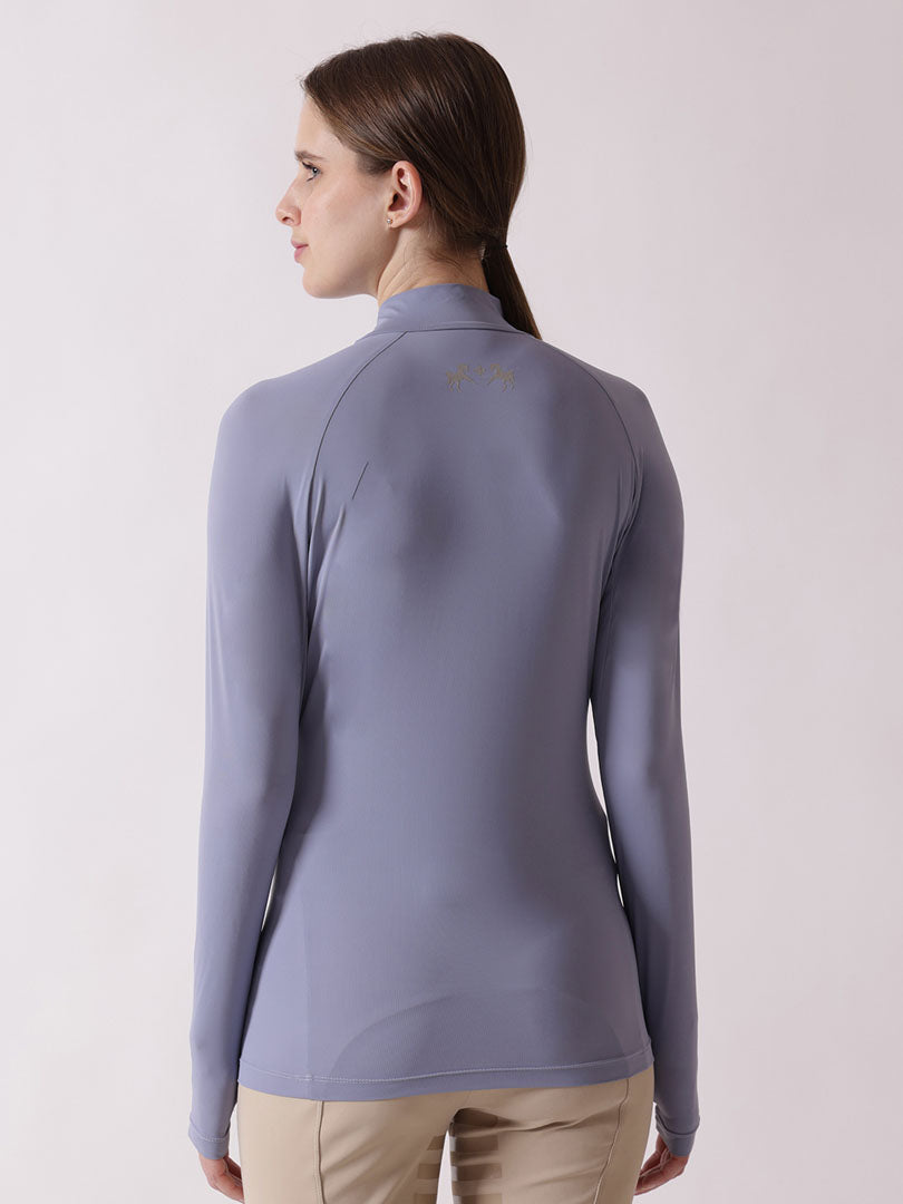 Woman wearing a light purple long-sleeve top on a plain background
