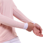 Person wearing a light pink long-sleeve shirt with white cuffs on a white background