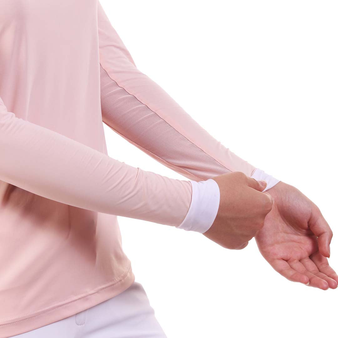 Person wearing a light pink long-sleeve shirt with white cuffs on a white background