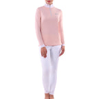 Person wearing a pink long-sleeve top and white pants on a white background