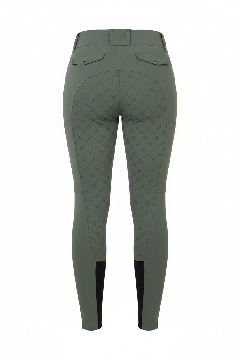 Green riding pants worn by a person on a gray background