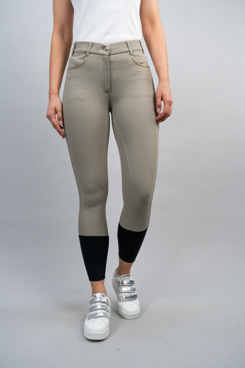 Person wearing beige riding pants with black socks on a gray background