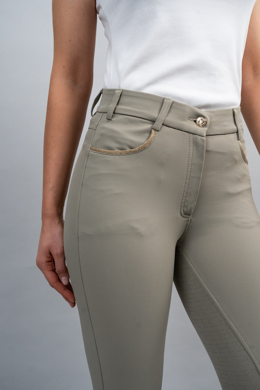 Person wearing beige riding leggings on a plain background