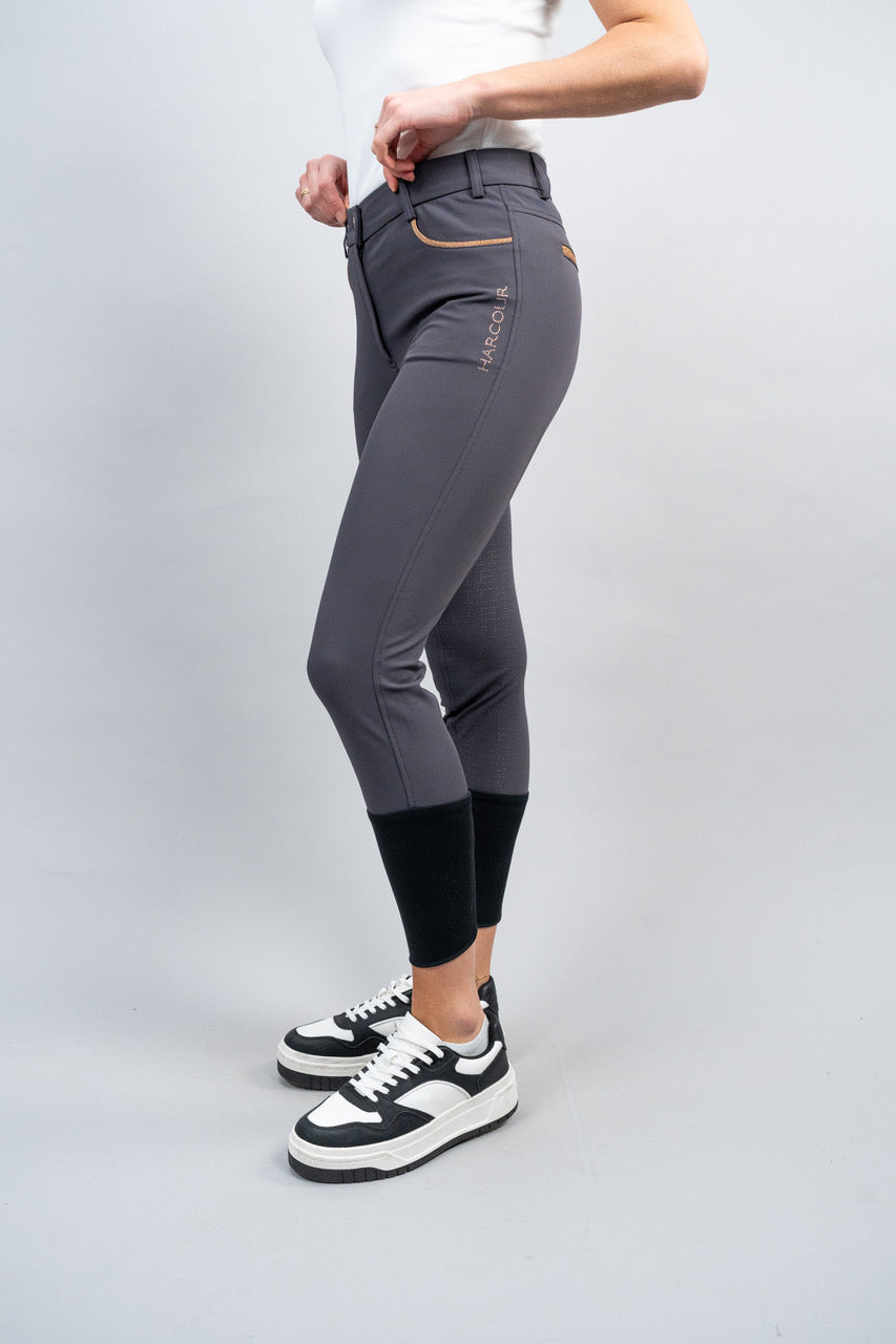 Person wearing gray riding pants with a white background