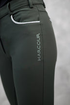 Dark green equestrian pants with 'HARCOUR' branding on a gray background
