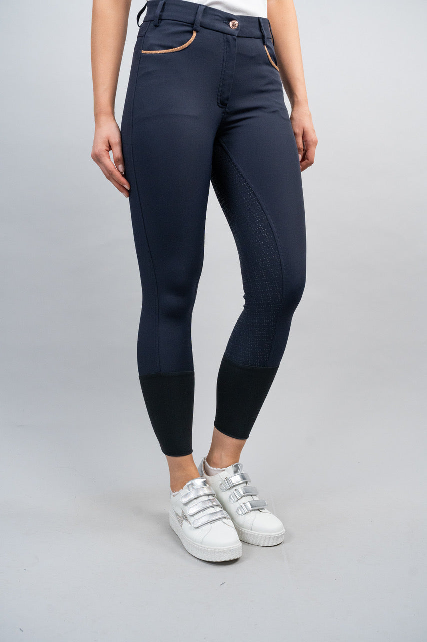 Person wearing navy riding pants on a gray background