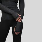 Person wearing dark gray long-sleeve top and leggings on a light gray background