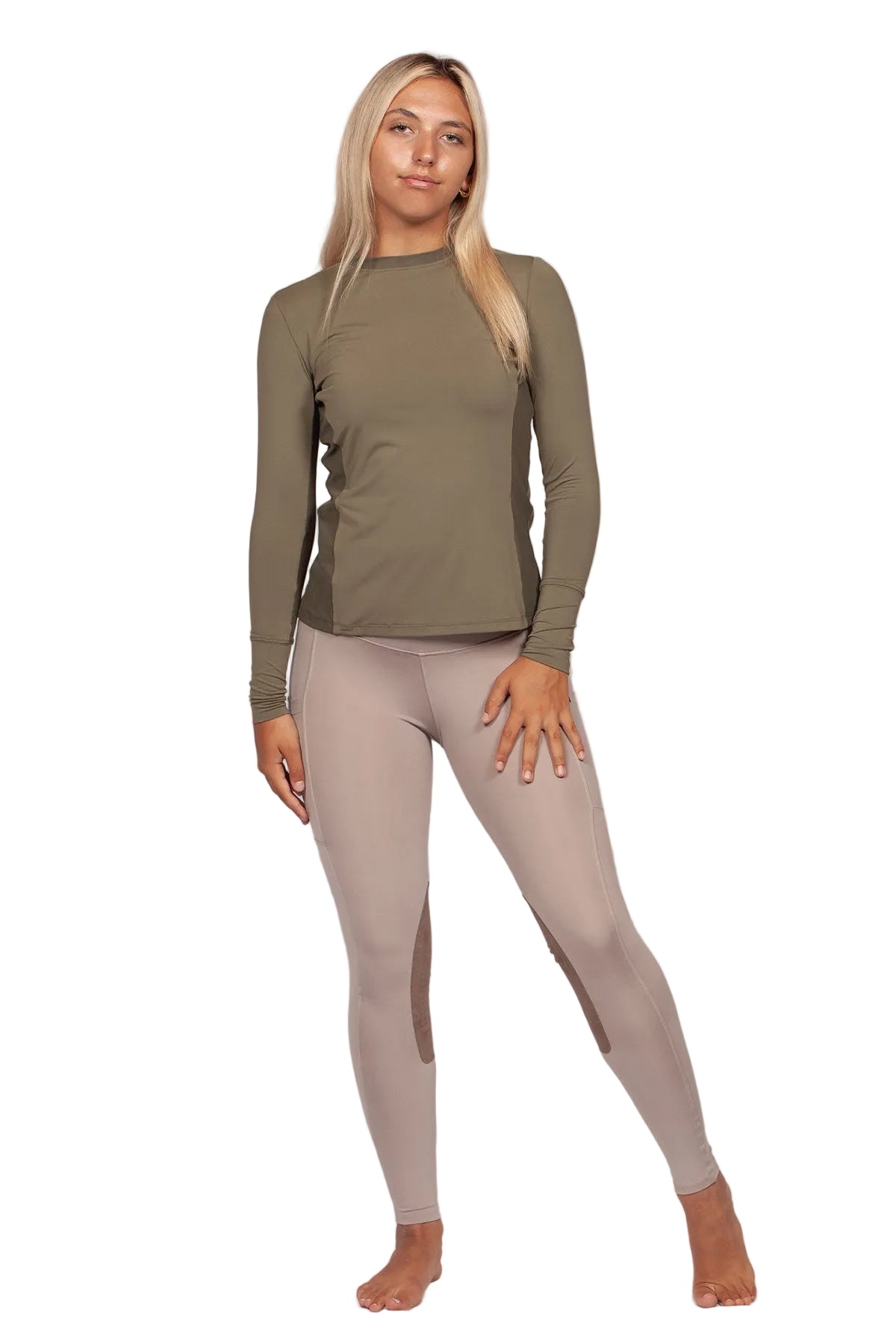 Woman wearing a green long-sleeve top and beige leggings on a white background