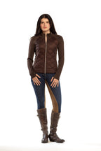 Woman wearing a brown quilted jacket, blue jeans, and brown riding boots on a white background