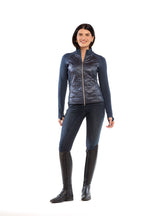 Woman wearing a black jacket, leggings, and tall boots on a white background