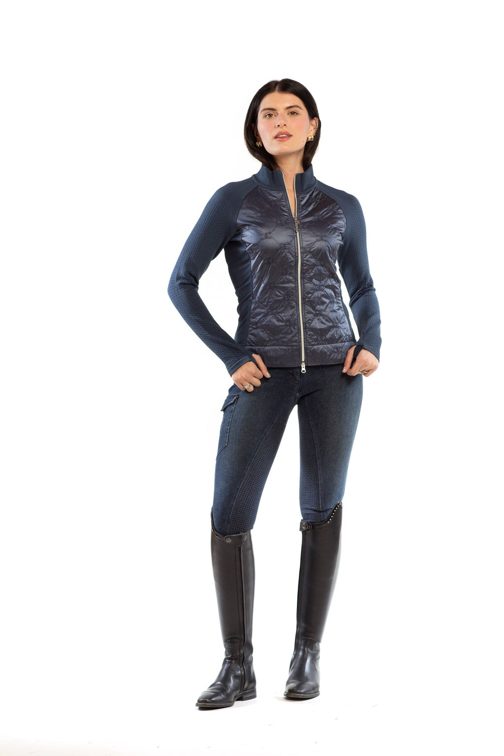 Woman wearing a blue jacket, black pants, and black boots on a white background