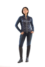 Woman wearing a blue jacket, black pants, and black boots on a white background