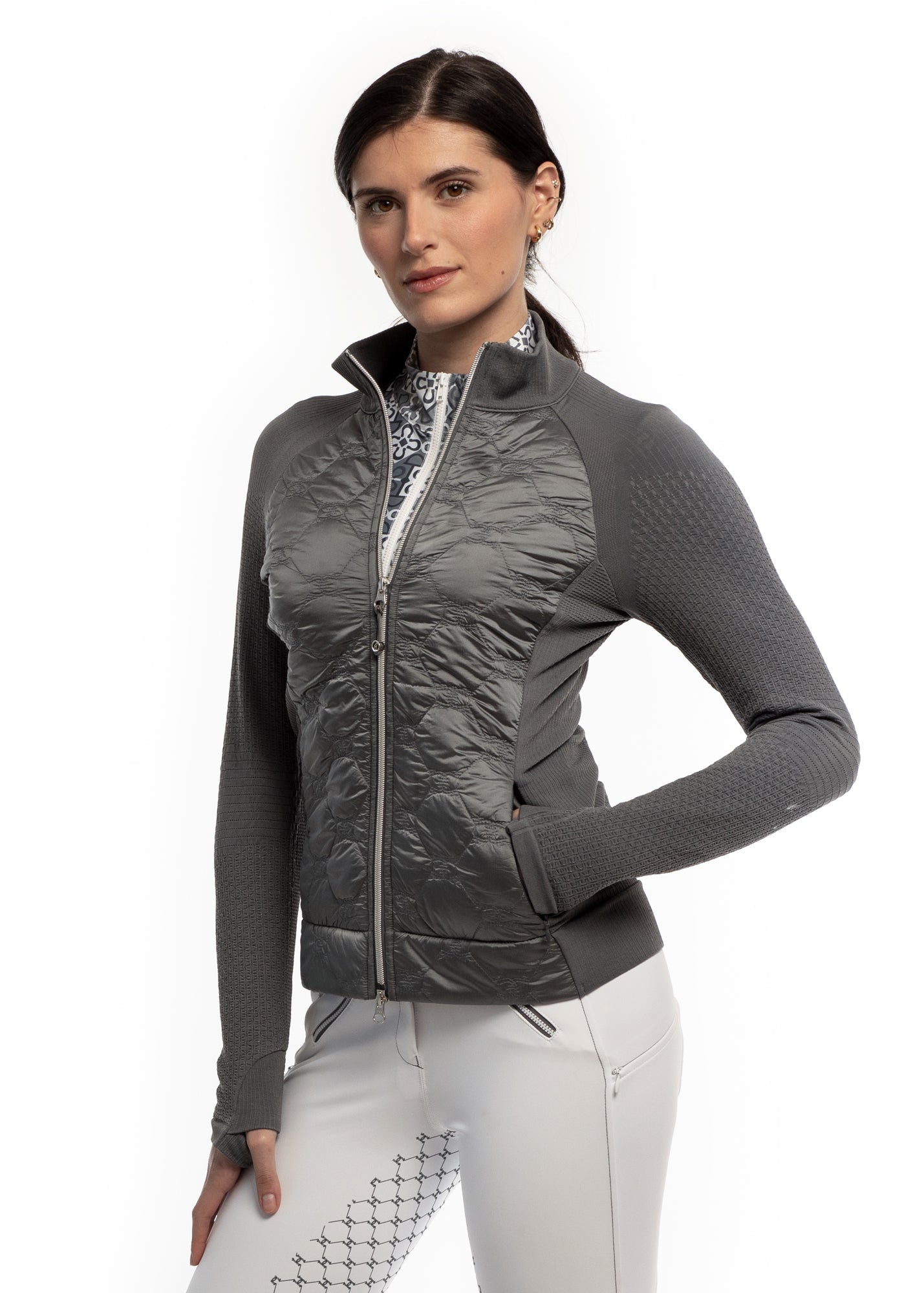 Woman wearing a gray quilted jacket with a white background