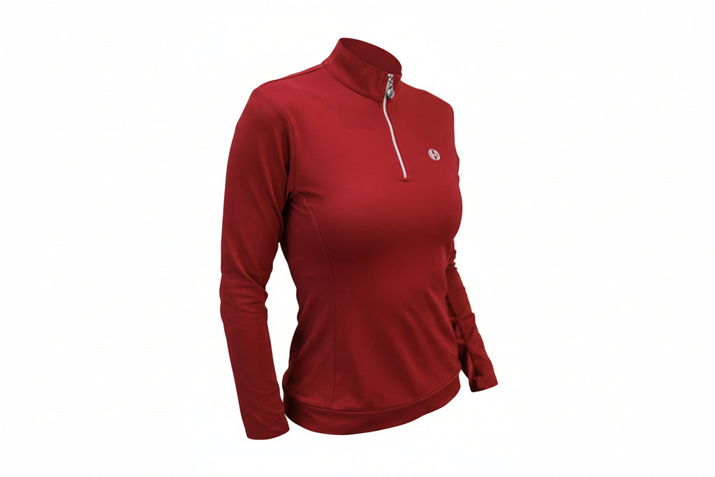 Woman wearing a red long-sleeve top with a small logo on a gray background
