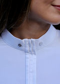 Close-up of a person wearing a light blue textured shirt with a collar.