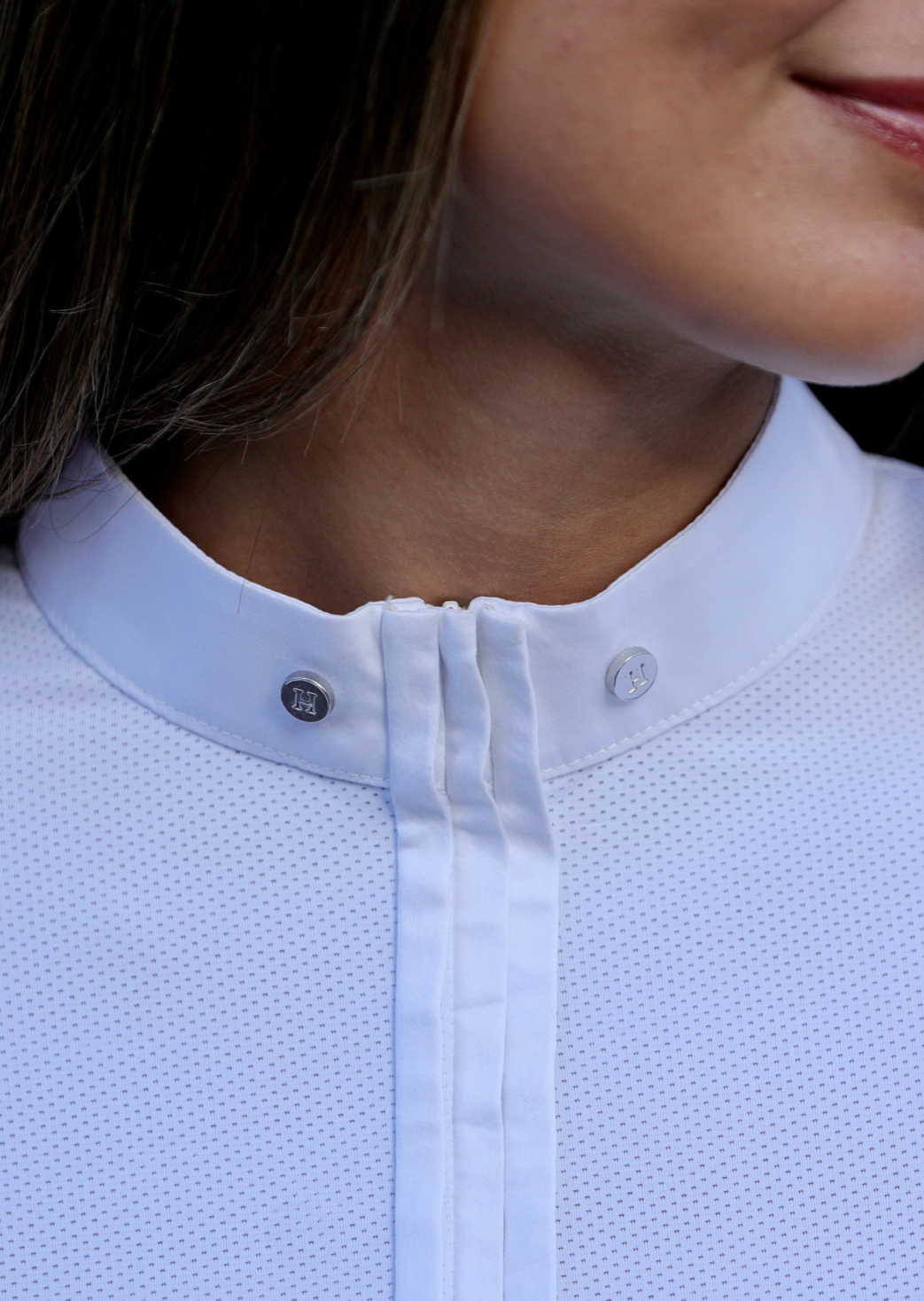 Close-up of a person wearing a light blue textured shirt with a collar.