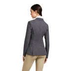 Person wearing a gray blazer and beige pants on a white background