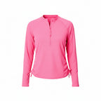 Woman wearing a pink long-sleeve shirt and blue shorts on a white background