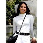 Woman in equestrian attire standing next to a horse statue