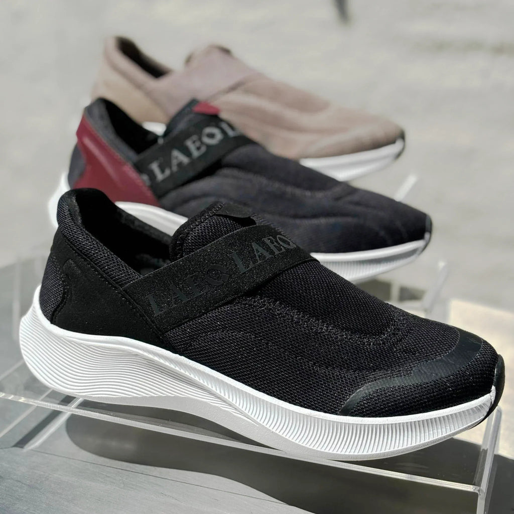 Black and brown shoes with 'Laeot' branding on a reflective surface.
