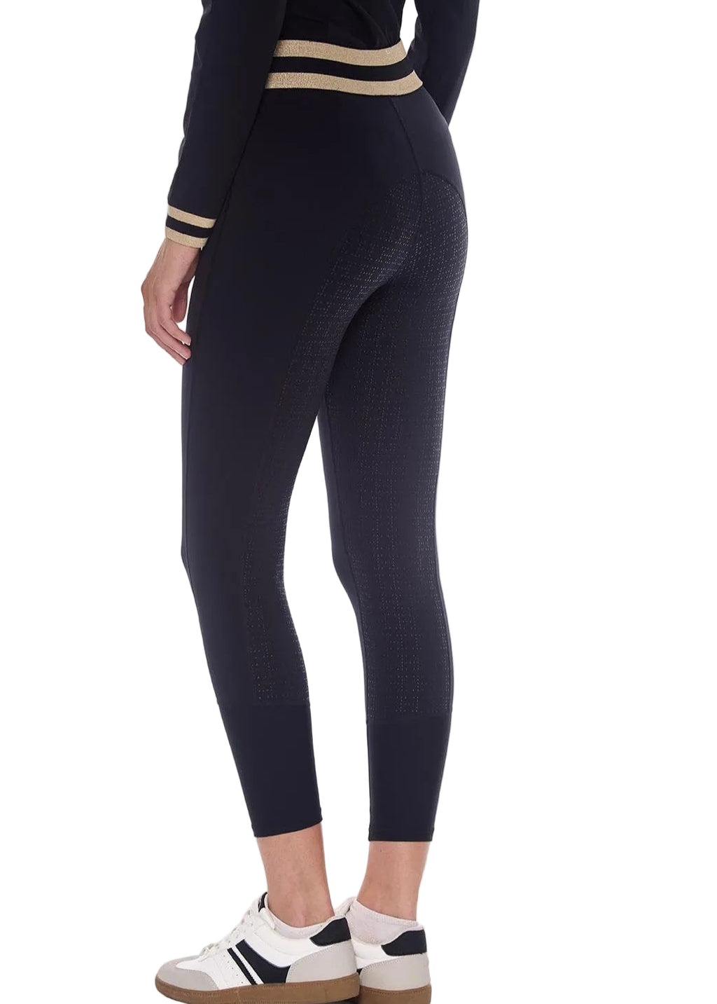 Person wearing black leggings with beige stripes on a white background