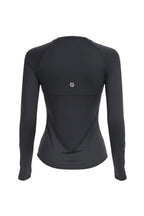 Woman wearing a black long-sleeve athletic top on a white background