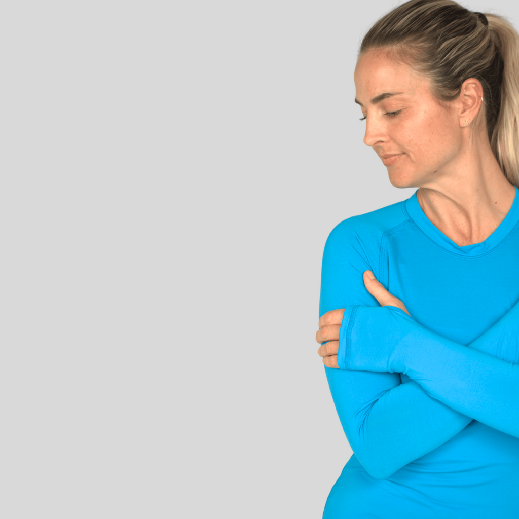 Woman wearing a bright blue long-sleeve top against a light gray background