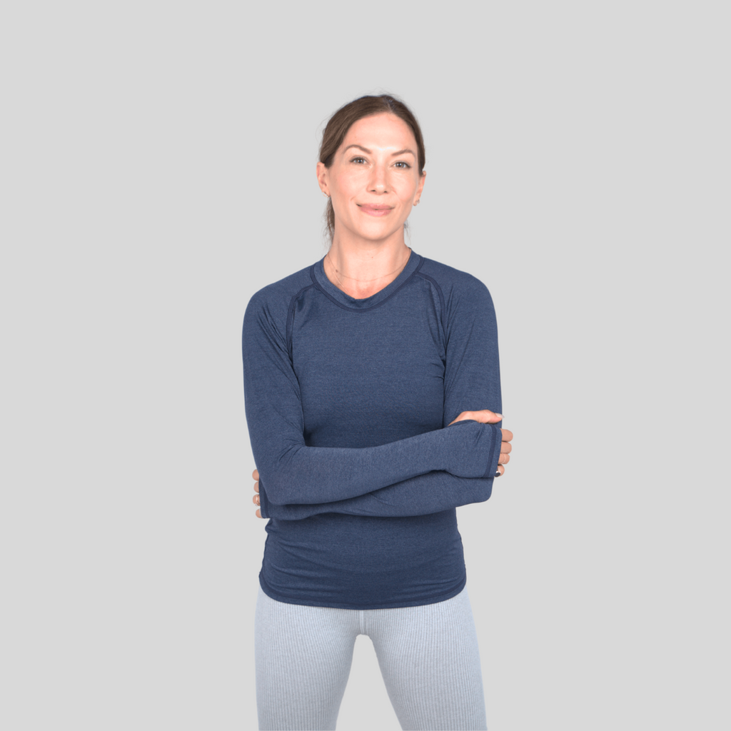 Woman wearing a blue long-sleeve shirt against a gray background