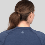 Person wearing a blue athletic shirt with a logo on the back against a gray background
