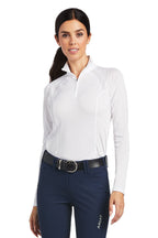 Woman wearing a white long-sleeve shirt and navy pants on a white background