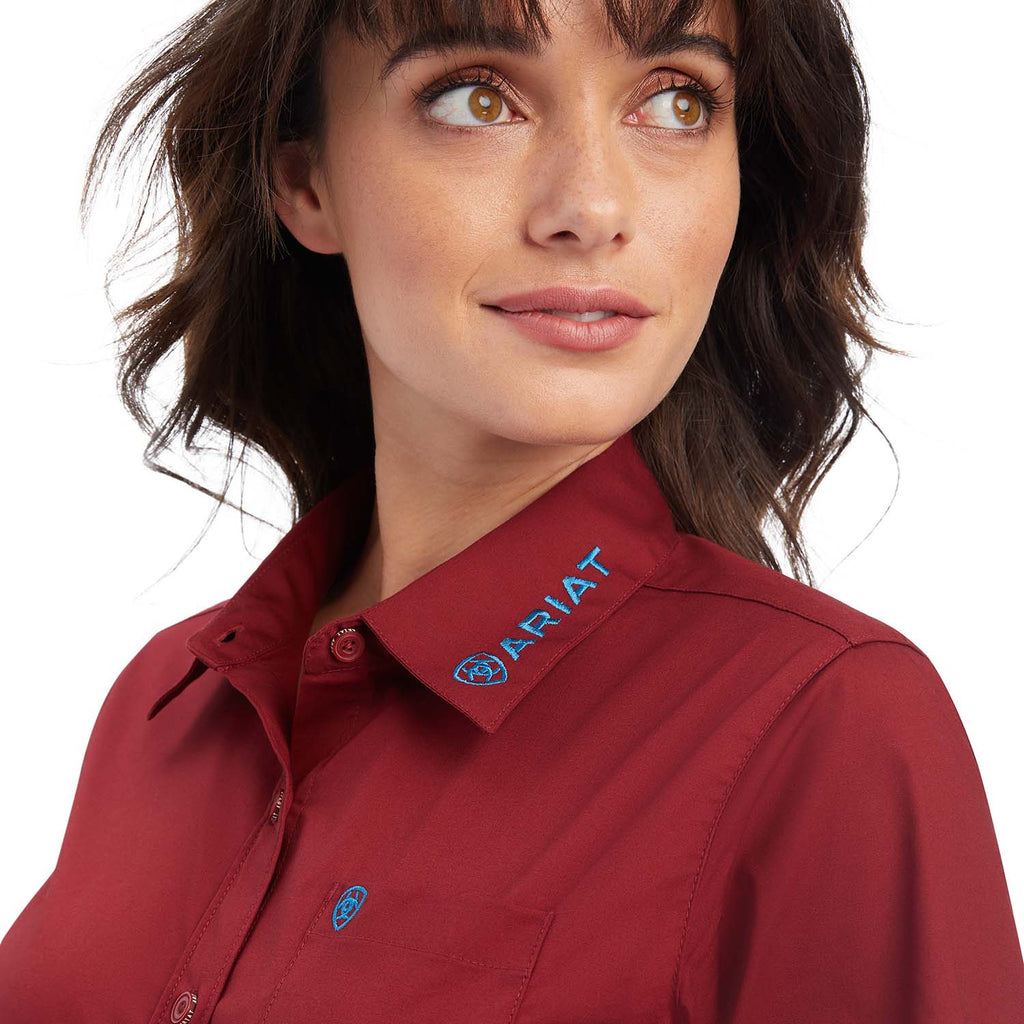 Woman wearing a red Ariat shirt with a close-up of the collar.