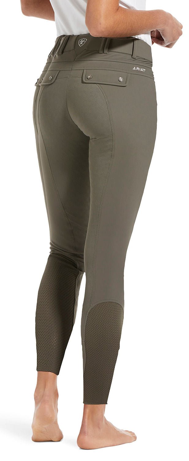 Olive green riding pants worn by a person on a white background