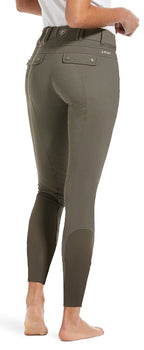 Olive green riding pants worn by a person on a white background