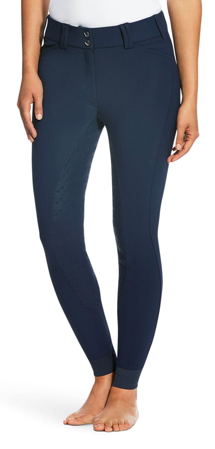 Navy riding pants worn by a person on a white background