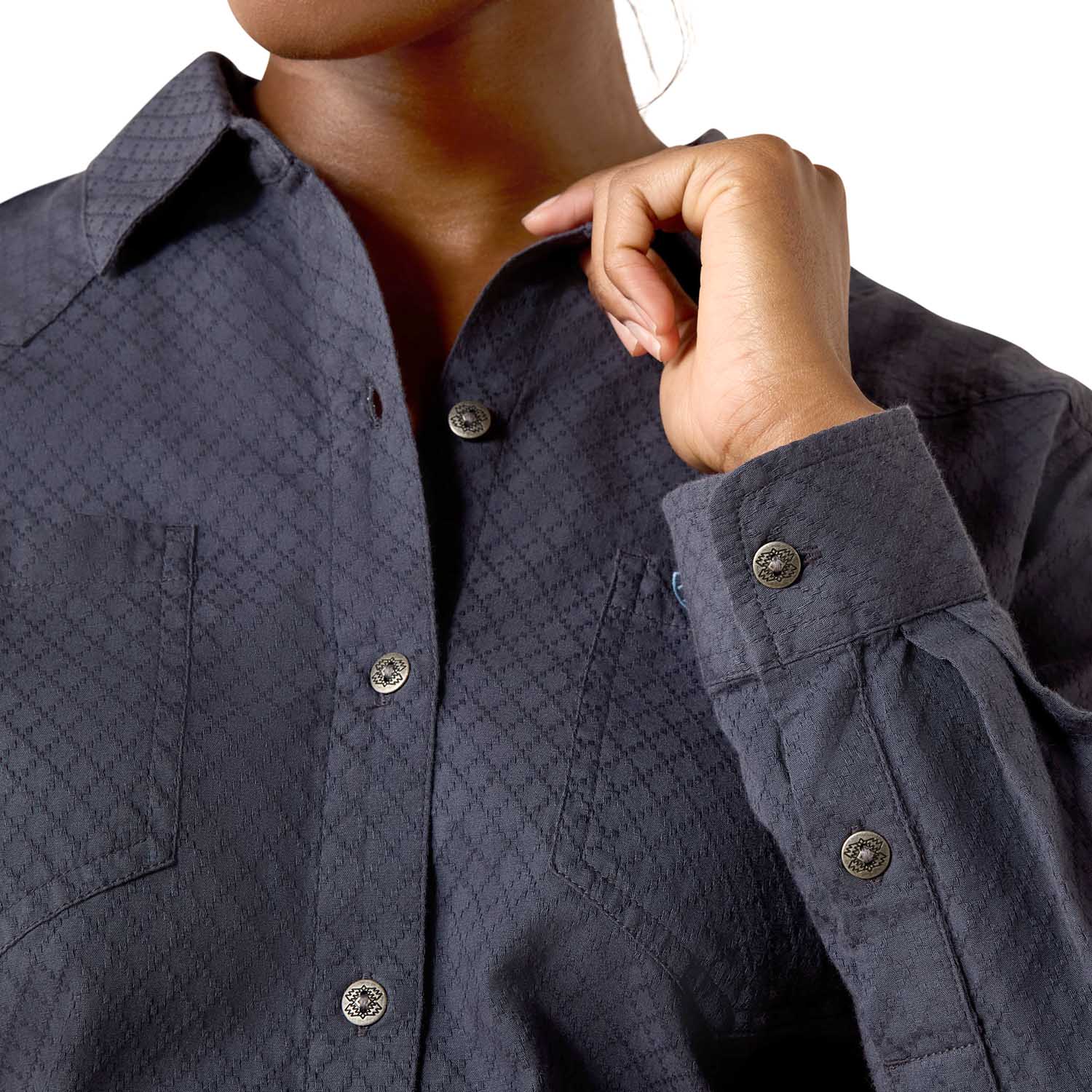 Close-up of a person wearing a dark blue textured shirt with buttons.
