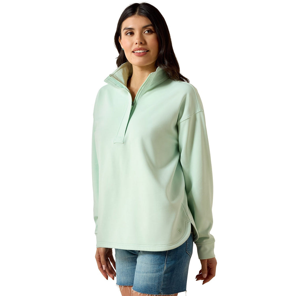 Woman wearing a light green pullover with a white background