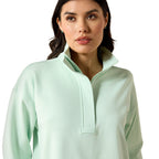 Woman wearing a light green pullover on a white background