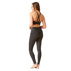 Woman wearing a black sports bra and leggings on a white background