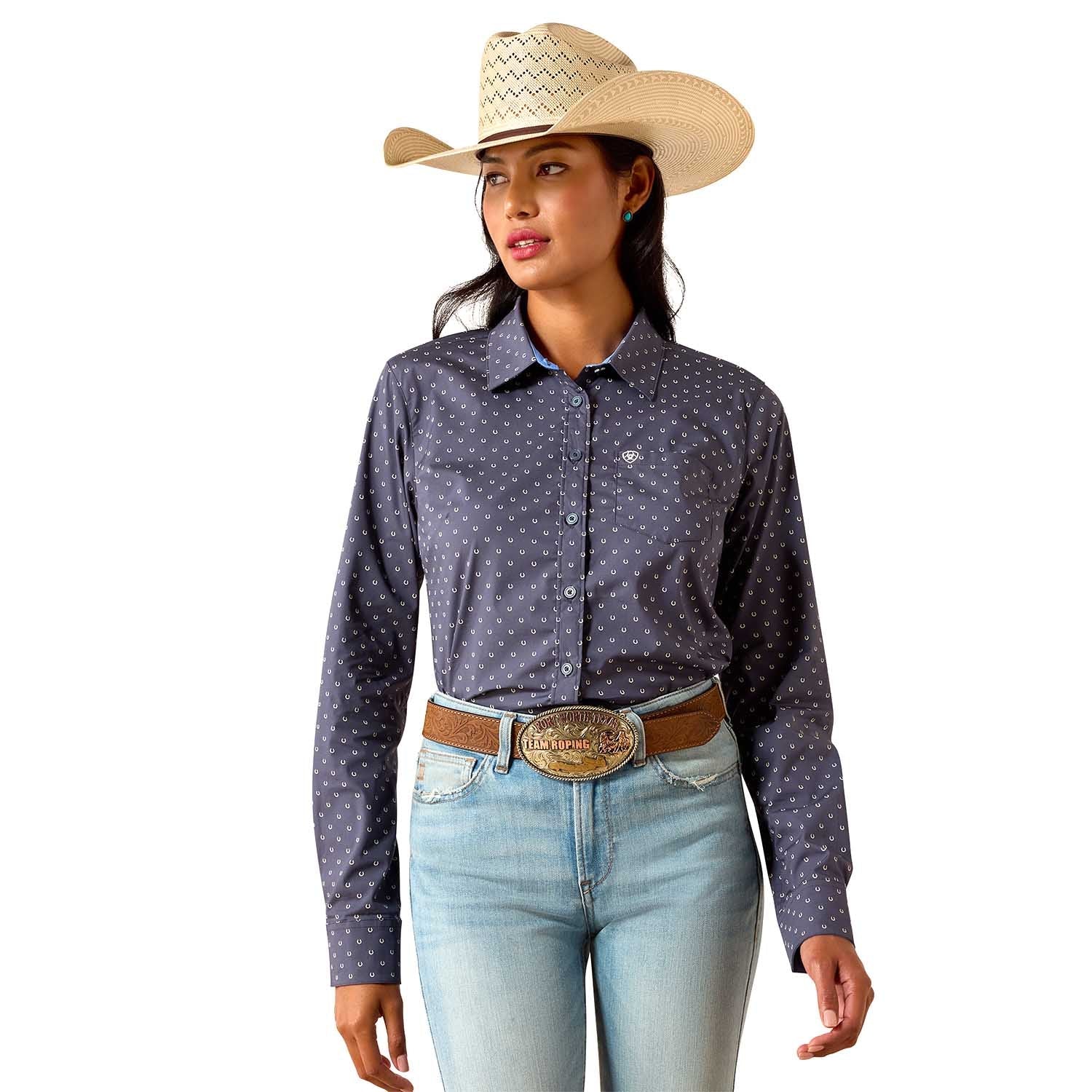 Woman wearing a patterned long-sleeve shirt, jeans, and a cowboy hat on a white background