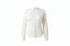 Woman wearing a white shirt with a bolo tie and dark jeans on a white background