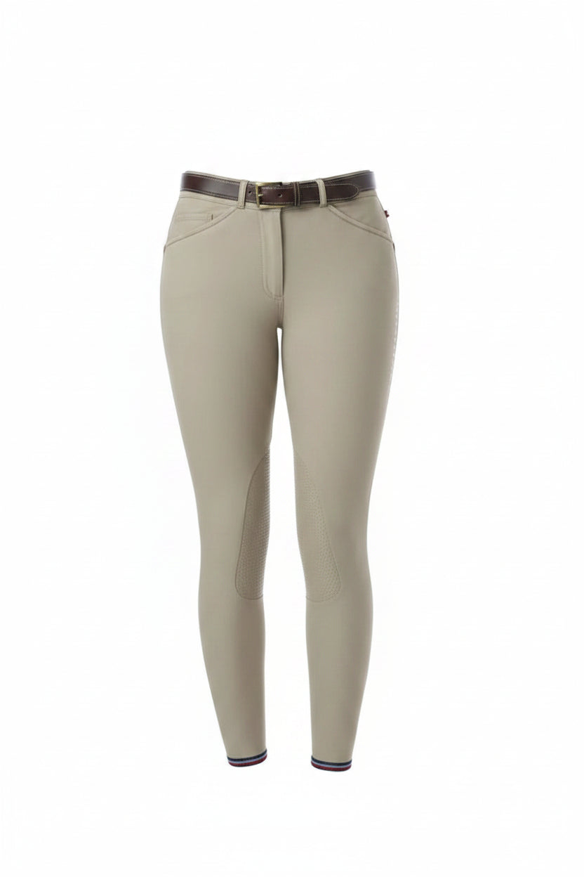 Person wearing beige riding pants with a white top on a white background