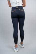 Person wearing navy riding pants with a white background