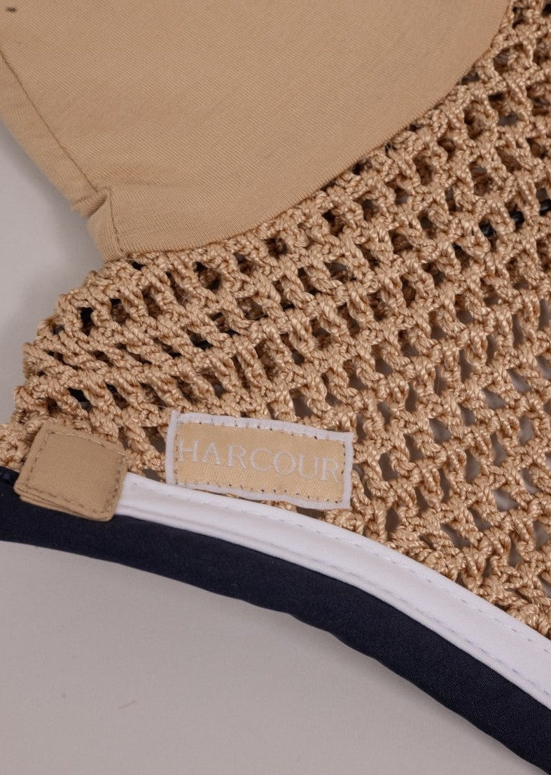 Close-up of a beige woven bag with a visible brand label on a neutral background