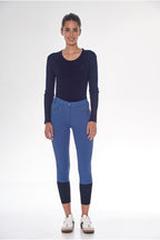 Person wearing a navy long-sleeve top and blue leggings on a white background